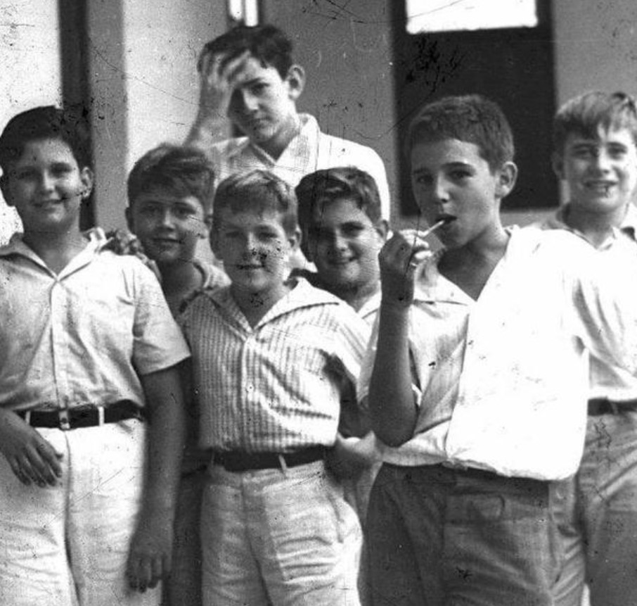 A Group Of Schoolboys Hanging Out Between Classes In Havana Cuba In 1937. The Young Man With The Lollipop Is Fidel Castro.