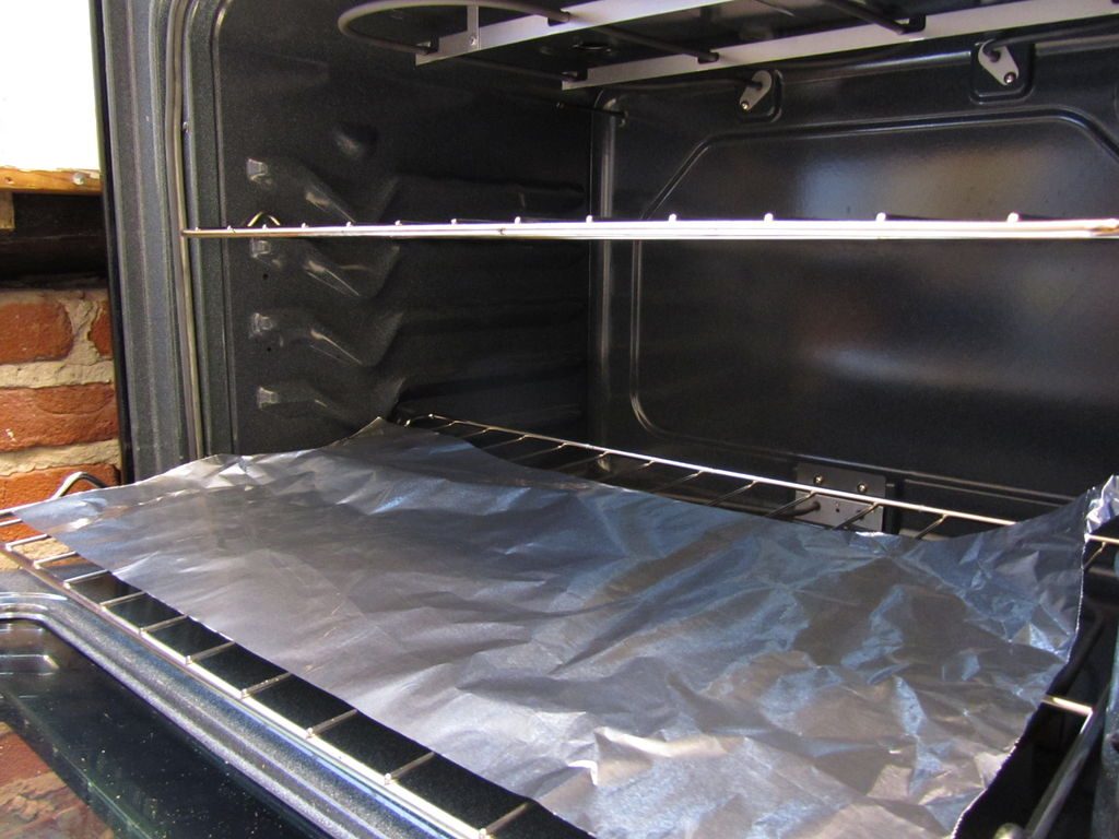 Rack Of Oven With Aluminum Foil To Catch Spills