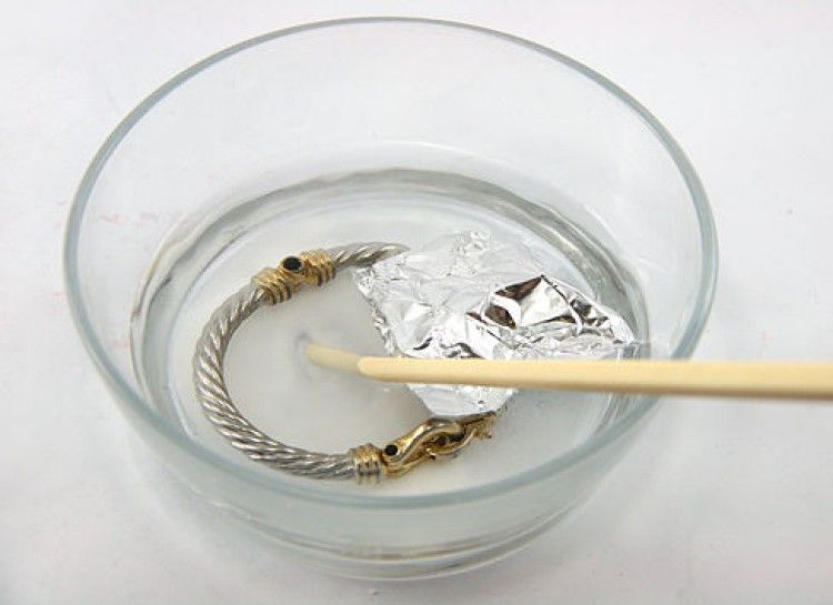 Gold Bracelet In Soapy Water With Floating Aluminum Foil